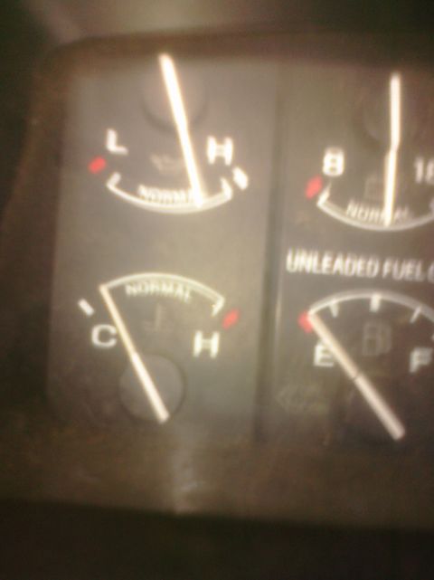 1995 Ford Bronco - Close-up of dashboard gauges, indicating low fuel and a cold engine temperature.