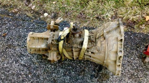 1995 Ford F-150 - Transmission removed from a vehicle, resting on the ground.