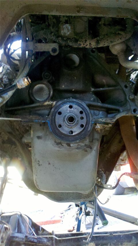 1995 Ford F-150 - Close-up view of the engine and transmission connection, showing the oil pan and mounting bolts.