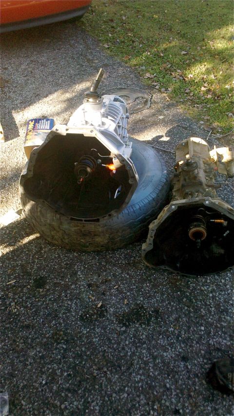 1995 Ford F-150 - Two manual transmissions are laid out on the ground, one resting on a tire.