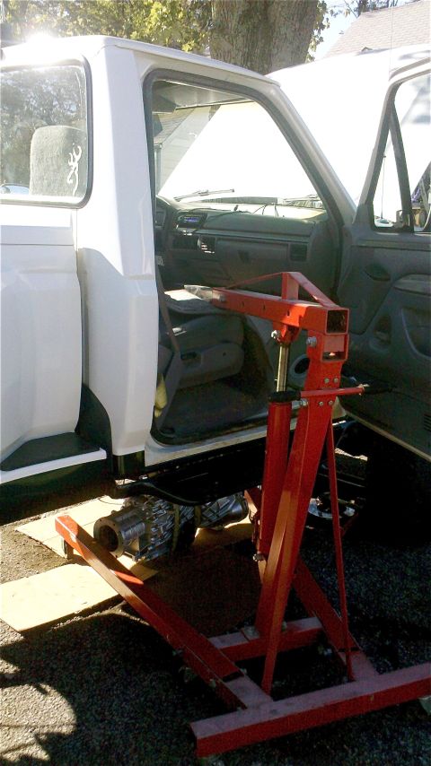 1995 Ford F-150 - Transmission removal in progress on a Ford F-Series truck, with an engine hoist ready to support the component.