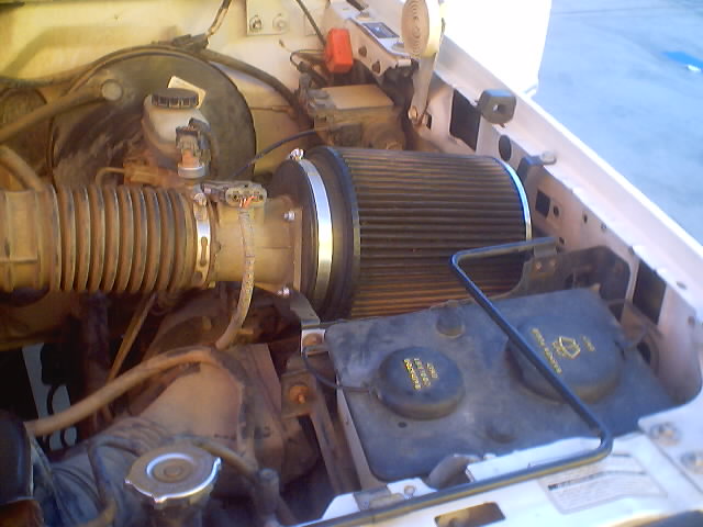 Engine bay of a white Ford Bronco with aftermarket cone air filter on the intake