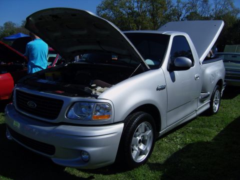 2007 Ford Mustang - A silver pickup truck is displayed with its hood and bed open at an outdoor event.