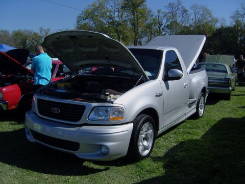 2007 Ford Mustang - A silver 2007 Ford F-150 SVT Lightning pickup truck is displayed with its hoods open at an outdoor event.