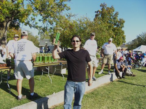 2007 Ford Mustang - Outdoor event with people and many trophies displayed on tables.