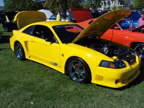 2007 Ford Mustang - Yellow Saleen Mustang at a car show, hood and engine exposed.
