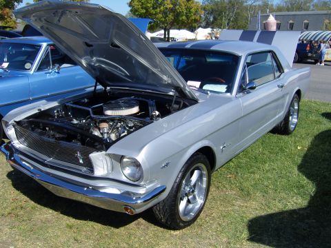 2007 Ford Mustang - A silver classic coupe, possibly a 1965 Mustang, is displayed with its hood open at an outdoor event.
