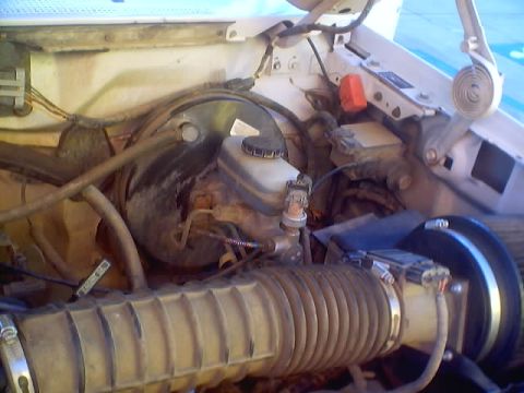 1996 Ford Bronco - Close-up view of a vehicle's engine bay, focusing on the air intake system and brake components.