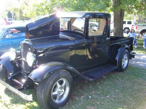 2007 Ford Mustang - A classic black pickup truck with a scooped hood is displayed outdoors.