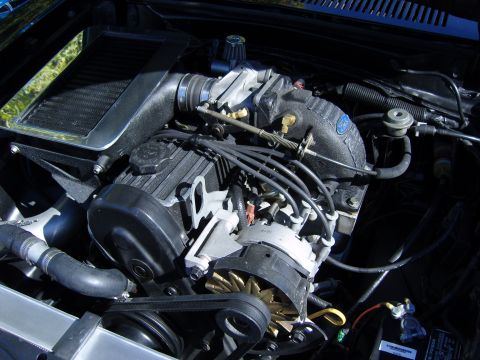 2007 Ford Mustang - Close-up view of a modified engine bay, highlighting the supercharger and intercooler system.