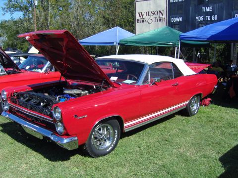 2007 Ford Mustang - A red 1967 Mercury Cougar convertible is displayed with its hood open at an outdoor event.