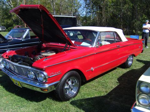 2007 Ford Mustang - A red 1962 Mercury Comet convertible is displayed with its hood open at a car show.