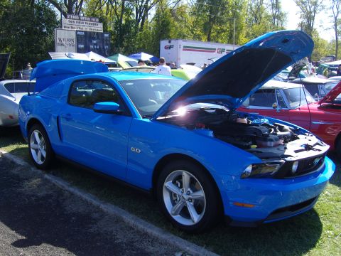 2007 Ford Mustang - A blue Ford Mustang is displayed with its hood open at an outdoor event.