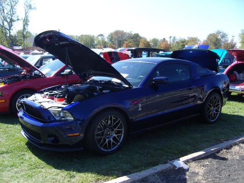 2007 Ford Mustang - A blue 2007 Ford Mustang is displayed with its hood and trunk open at an outdoor car show.