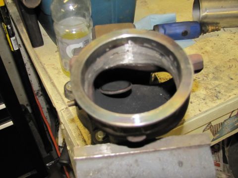 1993 Ford F-250 - A turbocharger wastegate actuator is secured in a vise, with workshop items visible in the background.
