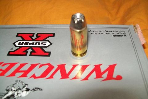 2000 Chevrolet Tahoe - A single ammunition cartridge is positioned on a box with prominent red branding.