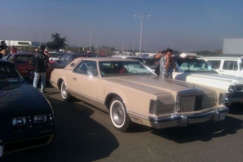 1991 Ford LTD Crown Victoria - A beige coupe from the late 1970s is parked at an outdoor event with other vehicles.