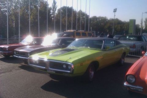 1991 Ford LTD Crown Victoria - A lime green 1971 Dodge Charger is parked in a line of cars at an outdoor show.