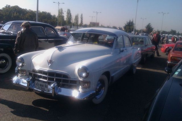 White 1950s Cadillac sedan parked, front view. Texas license plate visible