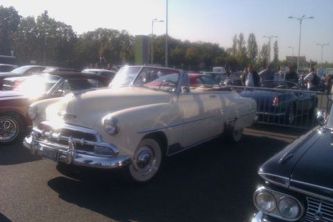 1991 Ford LTD Crown Victoria - A vintage cream-colored convertible is parked outdoors with other vehicles and people in the background.