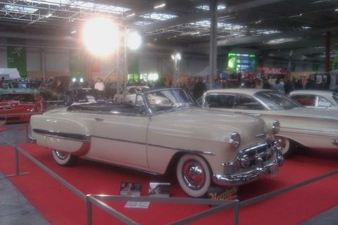 1991 Ford LTD Crown Victoria - A cream-colored 1953 Chevrolet Bel Air convertible is displayed indoors next to another vintage car.