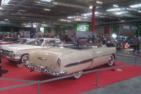 1991 Ford LTD Crown Victoria - A cream-colored convertible is displayed indoors on a red carpet, with other vehicles visible in the background.