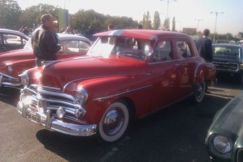 1991 Ford LTD Crown Victoria - This red sedan, likely a 1949 model, is parked at an outdoor event.