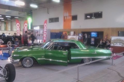 1991 Ford LTD Crown Victoria - A green 1963 Chevrolet Impala lowrider is displayed with its doors open.
