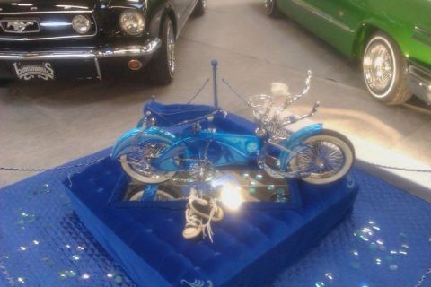 1991 Ford LTD Crown Victoria - A custom blue motorcycle is displayed indoors, with other vehicles visible in the background.