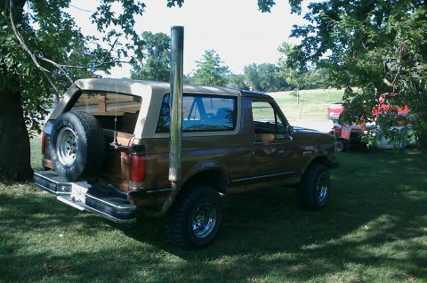 1987 Ford Bronco - This 1987 Ford Bronco is equipped with a tall exhaust pipe and a spare tire mounted on the rear.