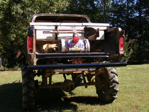 1978 Ford Bronco - This heavily modified pickup truck features oversized tires and a custom setup in the bed, with a license plate reading LE1 653.