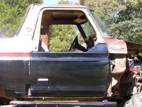 1978 Ford Bronco - This 1978 Ford Bronco is shown from the side, with its door open, revealing the steering wheel and interior.