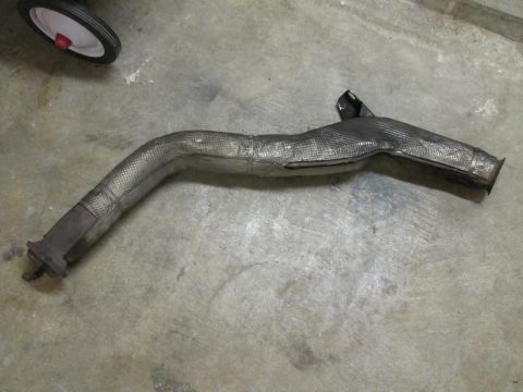 1995 Ford Bronco - Exhaust pipe section with heat shielding is shown on a concrete surface.