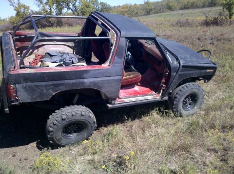 1986 Ford Bronco - This modified Ford Bronco features a roll cage and off-road tires, with its doors removed.