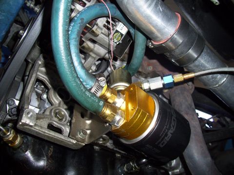 1995 Ford Probe - Close-up of an aftermarket oil filter housing and plumbing attached to an engine block.