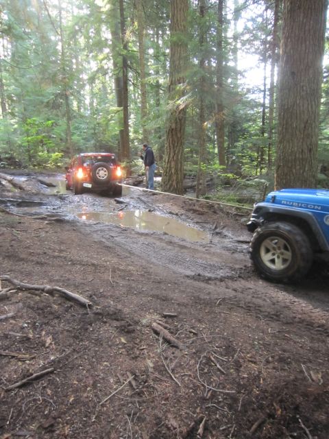 2008 Jeep Wrangler - Two Jeep Wranglers navigate a muddy trail, with one appearing stuck and the other providing assistance.