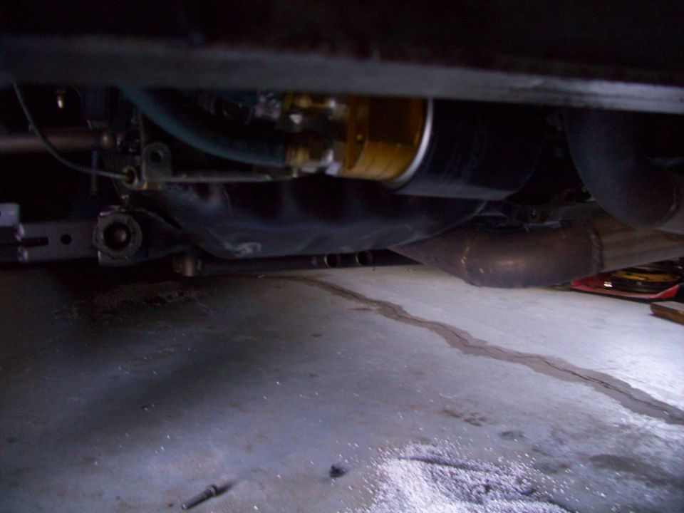 Underside view of car showing oil filter and exhaust pipe