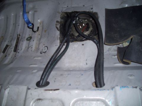 1995 Ford Probe - The interior floor pan of a vehicle shows a fuel pump assembly with attached hoses and wiring.