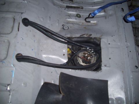 1995 Ford Probe - Close-up view of a vehicle's fuel pump assembly, showing hoses and securing straps.