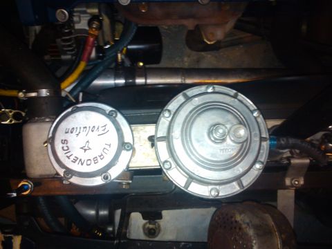 1995 Ford Probe - Close-up of engine components, a Turbonetics Evolution fuel pressure regulator and another similar part.