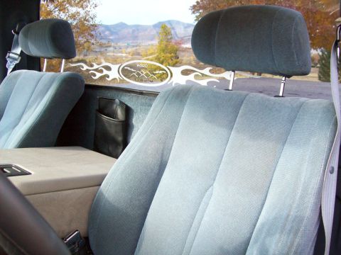 1993 Ford F-150 - The interior of a 1993 Ford F-150 shows light blue cloth seats and a decal on the rear window.