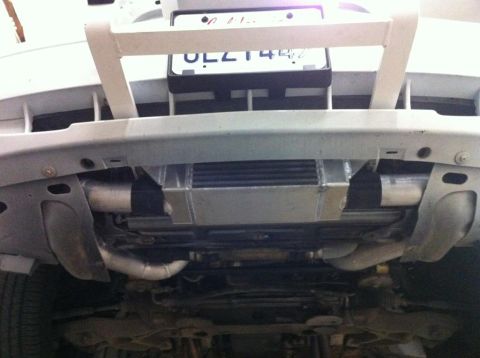 2004 Ford Crown Victoria - Aftermarket intercooler and piping are visible beneath the front bumper of a silver vehicle.