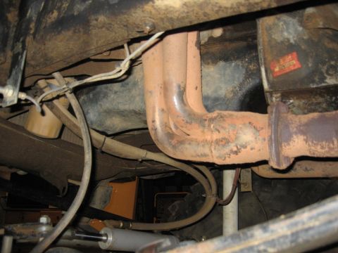 1979 Ford Bronco - Exhaust manifold and pipes are visible, along with various hoses and suspension components.