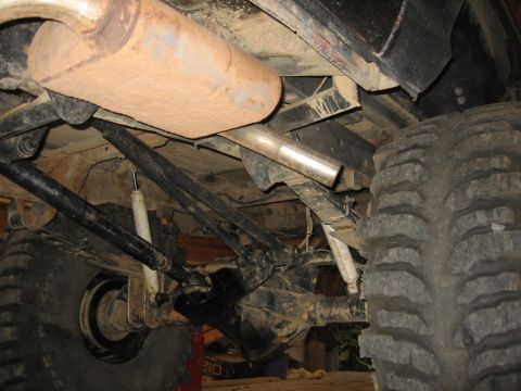 1979 Ford Bronco - Underside view of a vehicle's rear suspension and exhaust components, showing heavy-duty off-road tires.