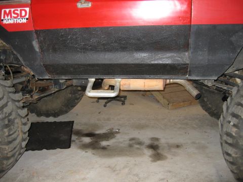 1979 Ford Bronco - The photo shows the lower body and undercarriage of a vehicle, focusing on the exhaust system and large tires.
