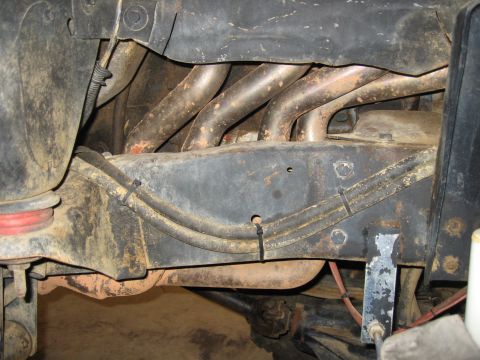 1979 Ford Bronco - Close-up view of a vehicle's exhaust manifold and frame components.