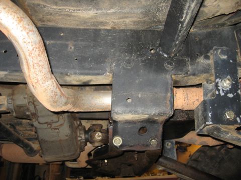 1979 Ford Bronco - Close-up of a vehicle's undercarriage, focusing on the exhaust system and drivetrain components.