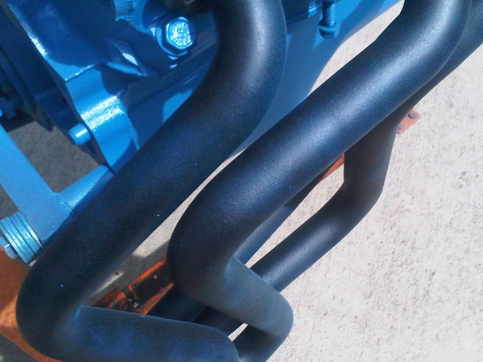 Blue engine block with black exhaust manifold pipes