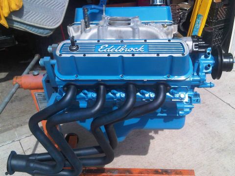 1985 Ford Bronco - Close-up of a blue Edelbrock V8 engine, black headers and an intake manifold.
