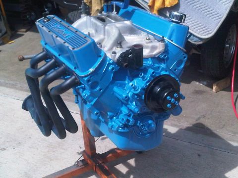 1985 Ford Bronco - A freshly painted V8 engine sits on a stand, ready for installation.